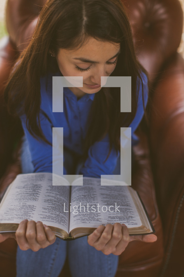 A woman sitting reading a Bible