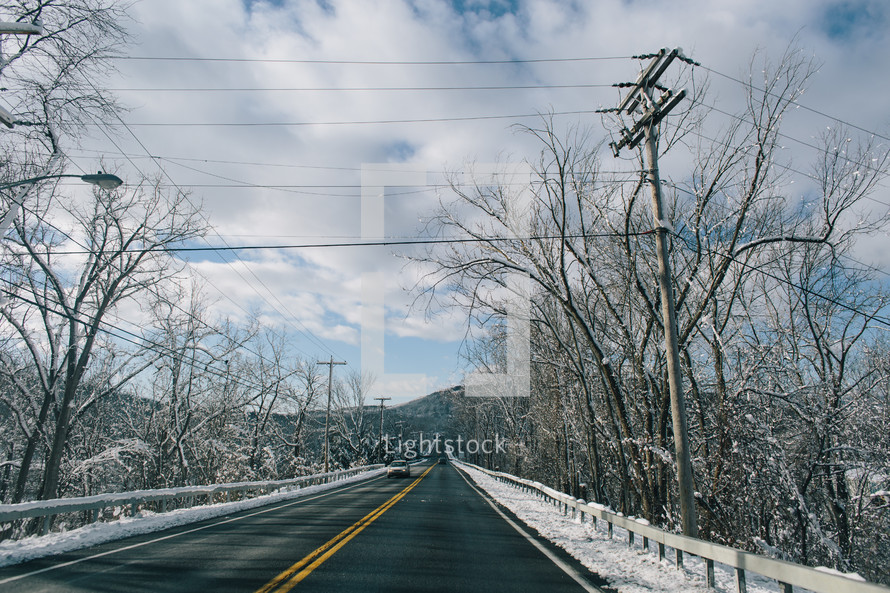 power lines over a road and snow 