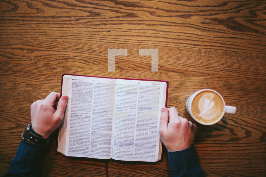 man reading a Bible and cappuccino 