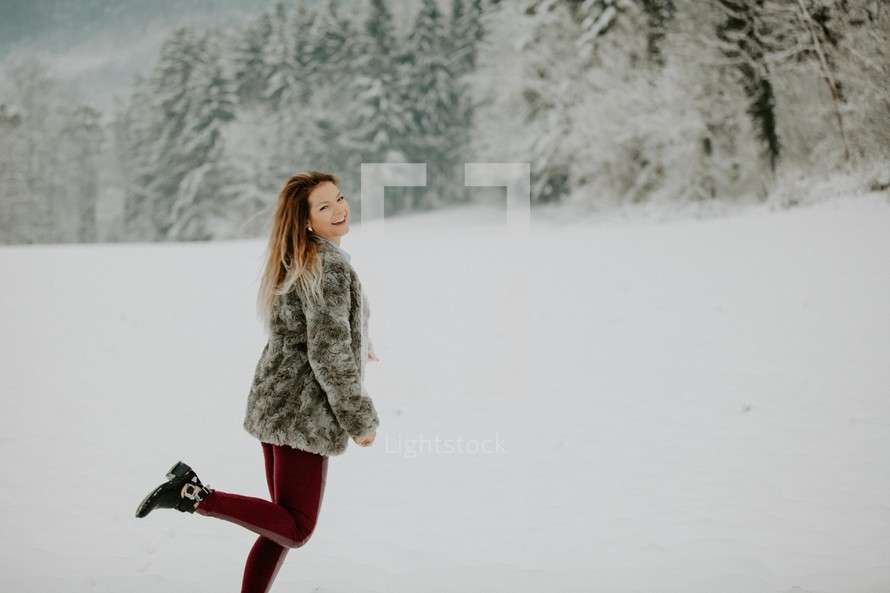 happy woman standing in snow 