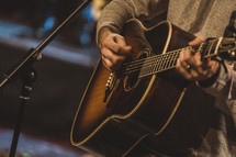 man playing an acoustic guitar 