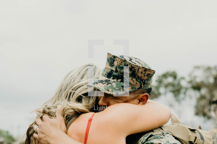 Military wife hugging her husband returning from battle 