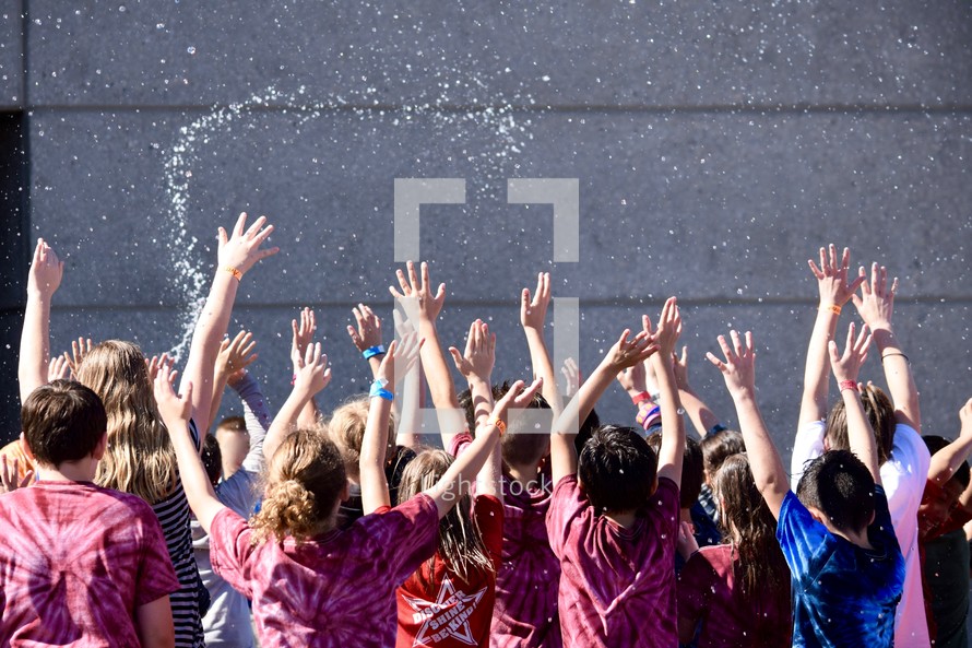 excited children being splashed with water 