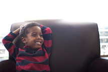 a child relaxing in a leather chair 