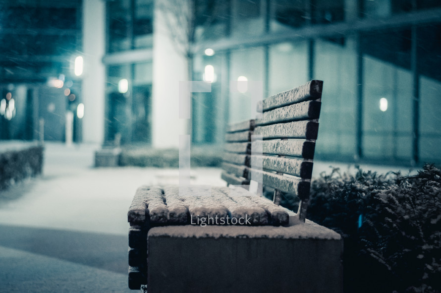 snow on a bench at night 