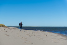 man walking on a beach in fall 