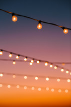 string of lights against an orange sky 