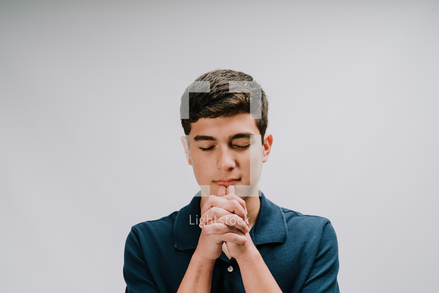 a teen boy praying 