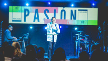 worship leader on stage holding a microphone 