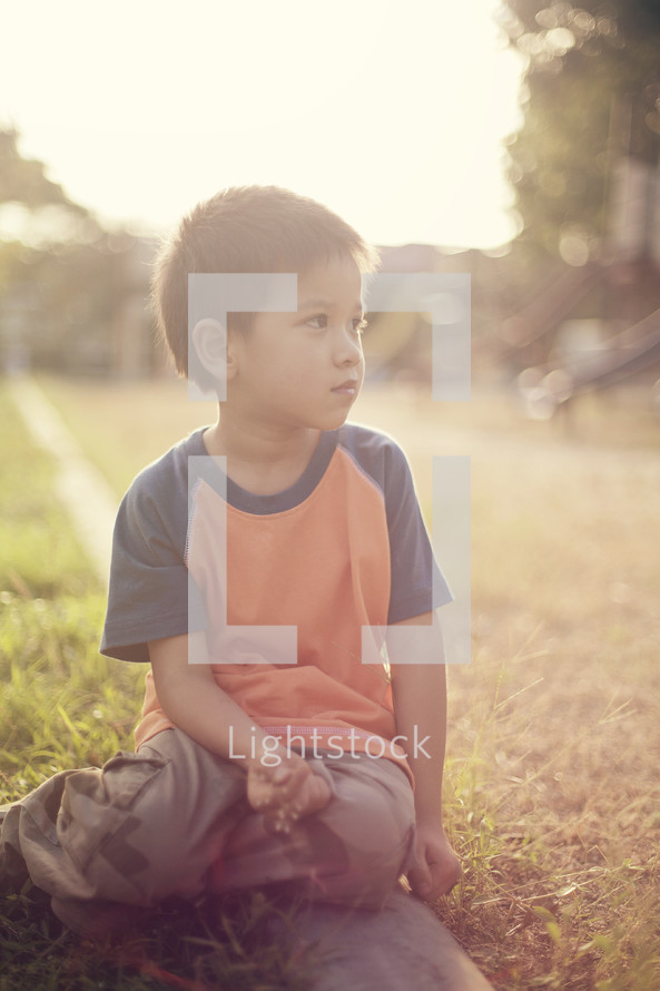 boy child sitting in the grass