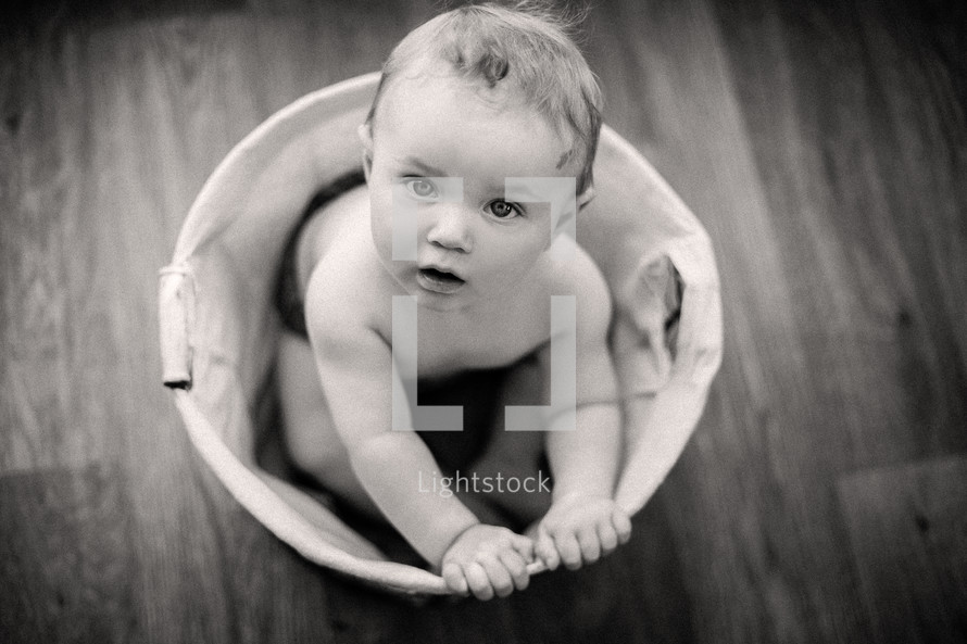 a toddler in a laundry basket 