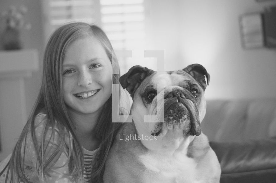 a little girl posing with her pet bulldog 