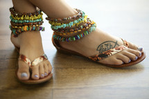 ankle bracelets and flip flops on a woman's feet 
