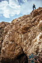 A man standing atop a cliff.