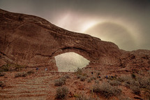 hikers and red rock arch 