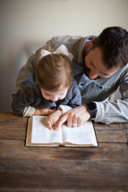 father and daughter reading a Bible together 