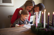 a family reading a Bible near an Advent wreath 