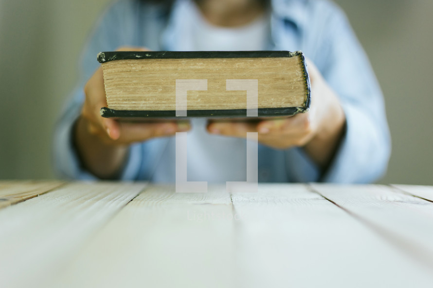 a woman holding a Bible up 