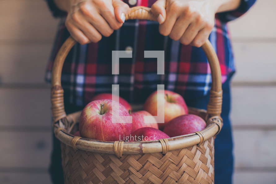 a man holding a basket of apples 