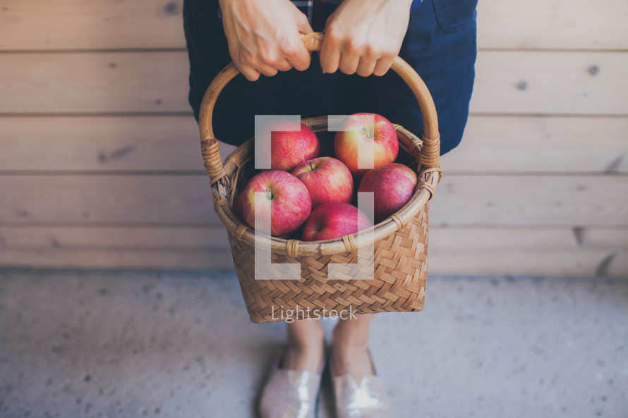 woman holding a basket of apples 
