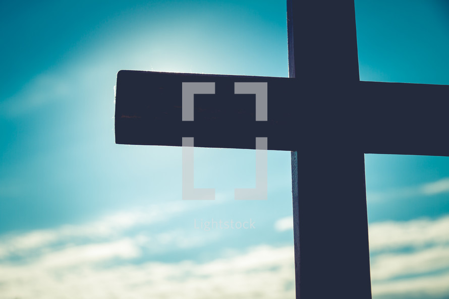 silhouette of a cross against a blue sky 