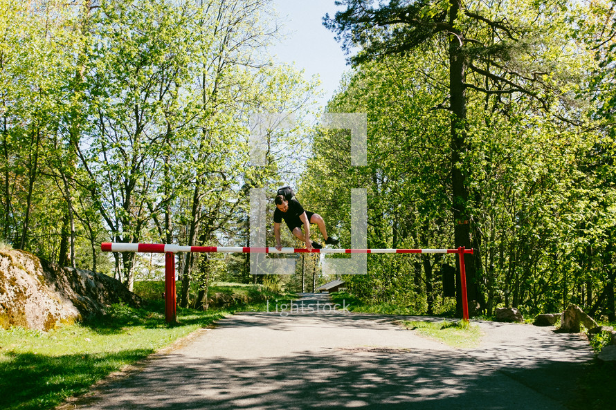 a man jumping over a gate 