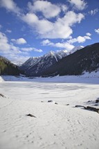 snow on a frozen lake in a valley 