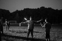 man holding sparklers outdoors at night 