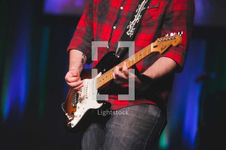 man playing an electric guitar on stage 