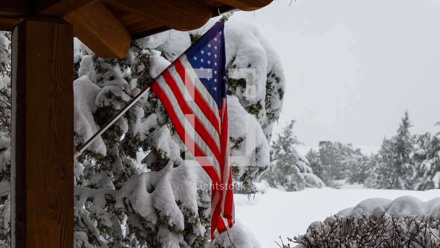 The flag of the United Staes with a winter background. 