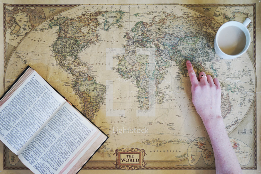 a woman pointing to a world map 