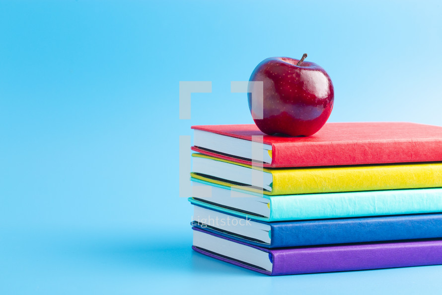 apple on a stack of school books 
