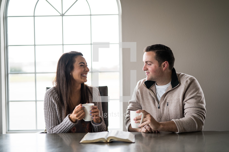 a couple studying a Bible together over coffee 