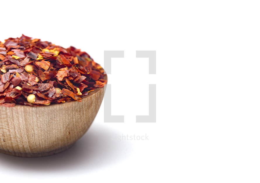 Crushed Red Pepper in a Wooden Bowl on a White Background