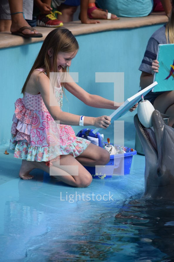 an excited child painting with dolphins 