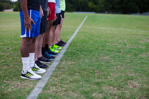 athletes standing in a row on a sports field 