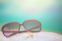sunglasses and starfish on a beach 