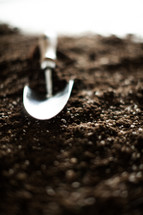 a shovel in potting soil 