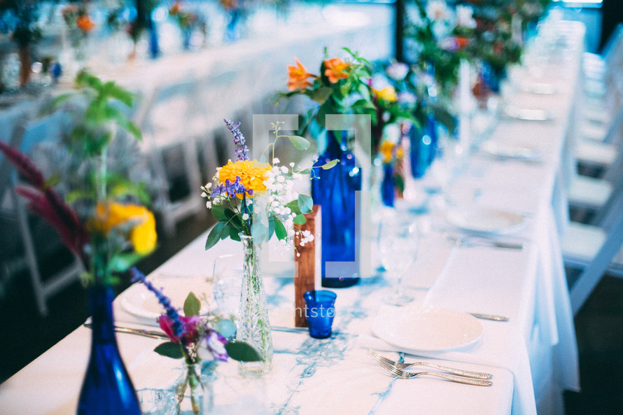 vases of flowers on a table set for a wedding reception 
