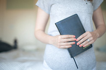 Woman holding closed Bible.