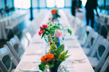 vases of flowers on a table at a wedding reception 