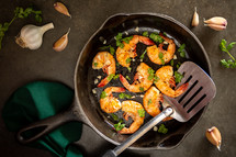 A cast iron skillet with grilled shrimp