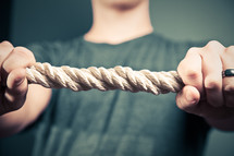 man holding onto a thick rope