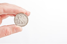 hand holding a half dollar coin