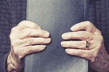 hands of an elderly woman holding a Bible