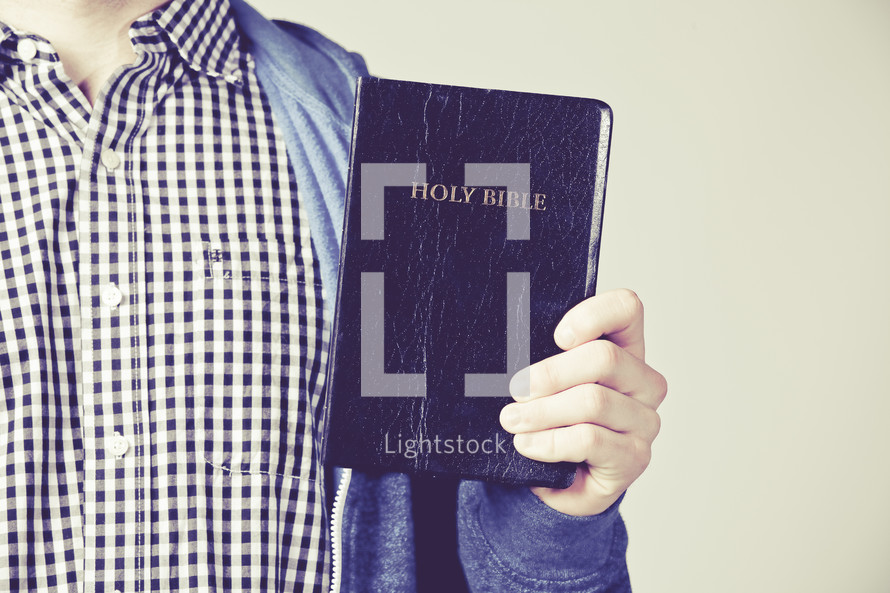 man holding up a Holy Bible