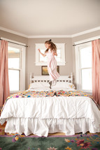 little girl jumping on the bed