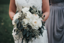 bride holding a bouquet of white roses 