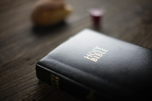 A leather Bible on a woodgrain table.