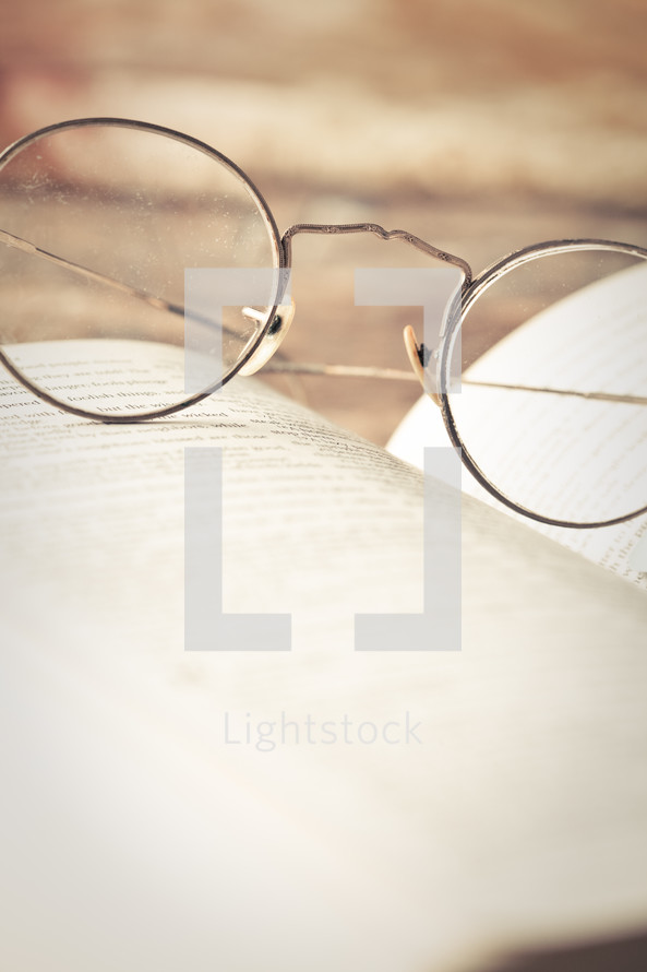 reading glasses on the pages of a Bible